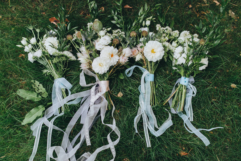 wedding flower bouquets with ribbons in grass