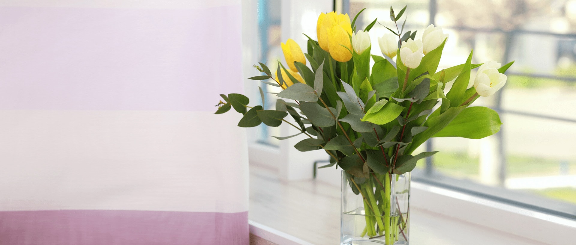 get well flowers in vase by window in hospital room