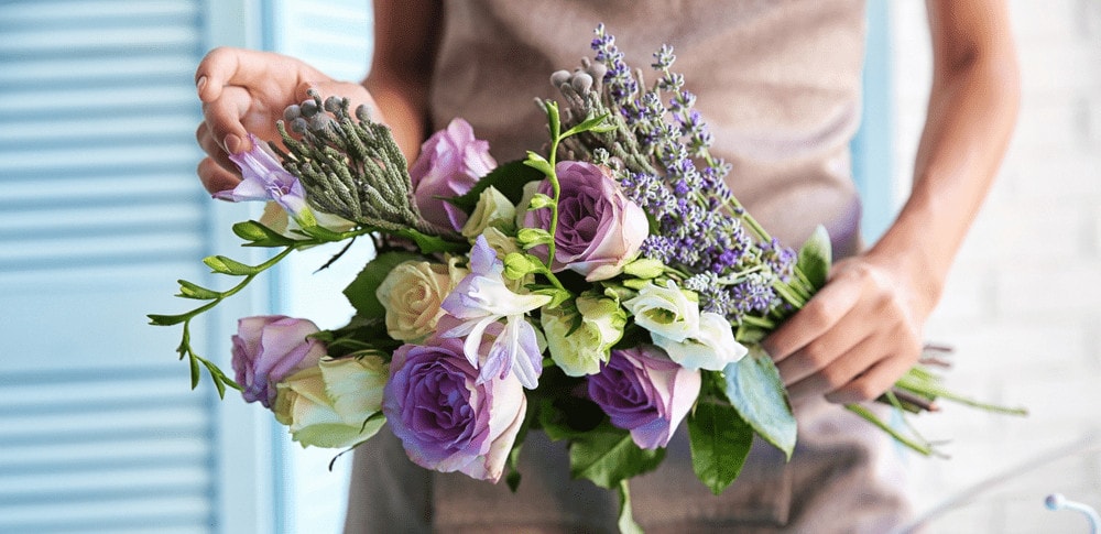 florist arranging lavender rose bouquet