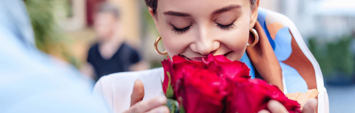young woman smelling red roses