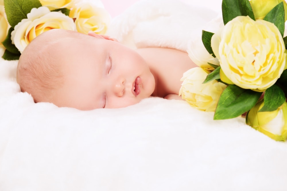 infant baby flowers on bed