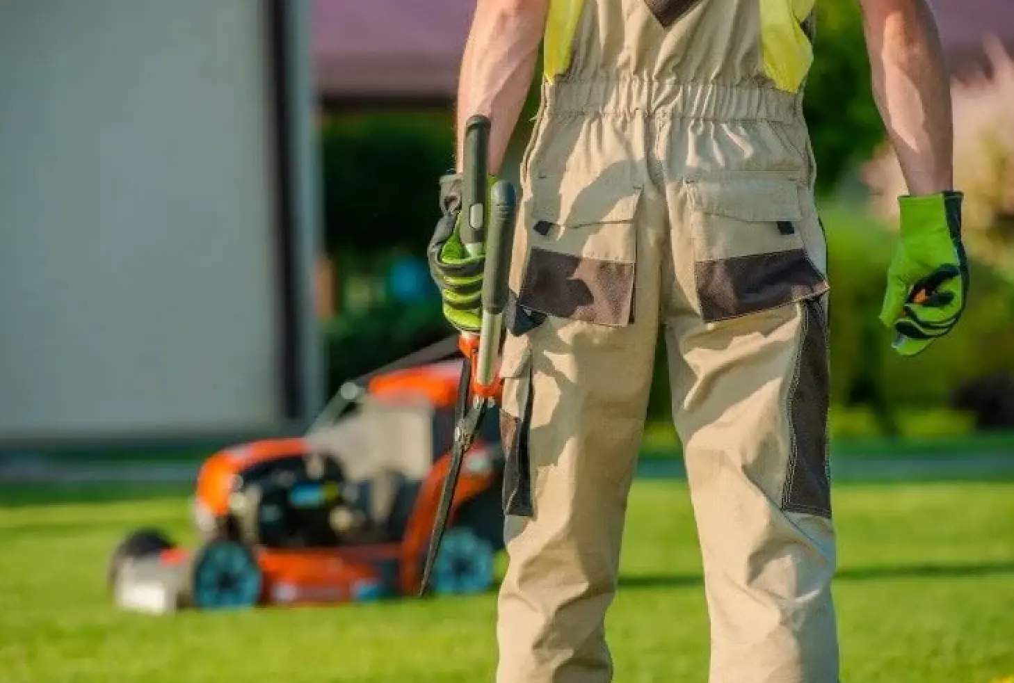 Landscaper working in yard holding hedge clippers